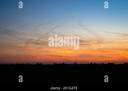 Beaucoup de contrailles dans le ciel du soir, formé par l'émission de vapeur d'eau de l'avion à haute altitude Banque D'Images