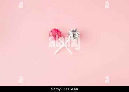 Lollipop candy and disco ball on lollipop stick on pink background. Flat lay. Top view. Minimal concept. Banque D'Images
