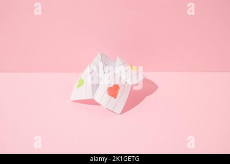 Jeu de paper origami fortune teller sur fond rose. Concept minimal. Banque D'Images