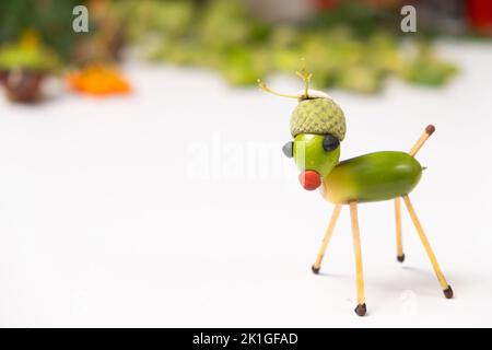 Un jouet de cerf fait d'acorns et de allumettes sur fond blanc avec un endroit pour le texte. Banque D'Images