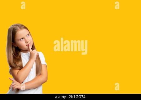 Enfant curieux. Expérience commerciale. Offre spéciale. Portrait de la jeune fille pensive incertaine pensant invisible option isolée sur l'empt jaune Banque D'Images