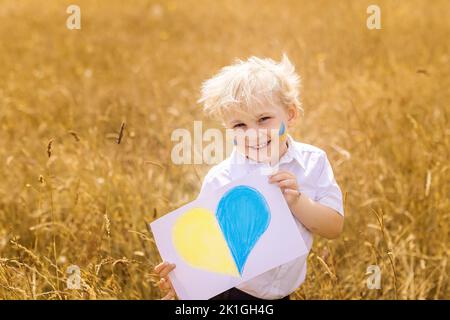 Arrêtez la guerre en Ukraine. Un garçon ukrainien avec drapeau ukrainien - jaune et bleu se dresse contre la guerre. Banque D'Images