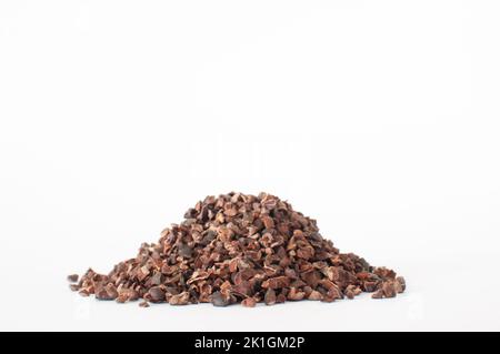 Pile de pointes de cacao brutes organiques, faible profondeur de champ au premier plan. Isolé sur fond blanc. Banque D'Images