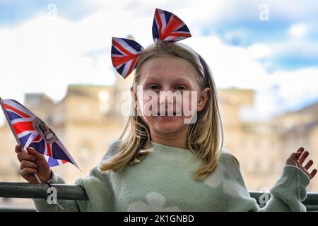 Londres, Royaume-Uni. 18th septembre 2022. (Permission parentale obtenue) Une fille fait passer son drapeau et attend avec sa famille. Les membres de la file d'attente publique attendent le long de la route pour les funérailles de la reine Elizabeth II sur le Mall à Westminster. Beaucoup ont apporté des couvertures, des drapeaux de jack d'Union, des sacs de couchage, des chaises, des ballons et même des tentes crédit: Imagetraceur/Alamy Live News Banque D'Images