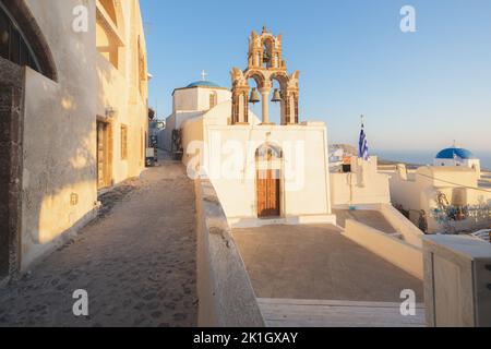 Pyrgos, Grèce - 12 septembre 2022: Le dôme bleu traditionnel et les cloches d'une église orthodoxe grecque pendant une heure d'or coucher de soleil avec vue sur l'Aegea Banque D'Images