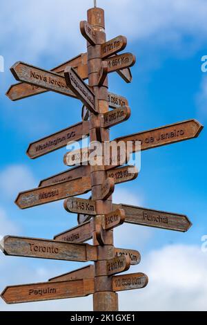 Flèches directionnelles sur un panneau indiquant les distances vers les villes du monde sur le terrain de l'Outeiro da Memoria, à Angra do Heroismo, l'île de Terceira, les Açores, le Portugal. Banque D'Images