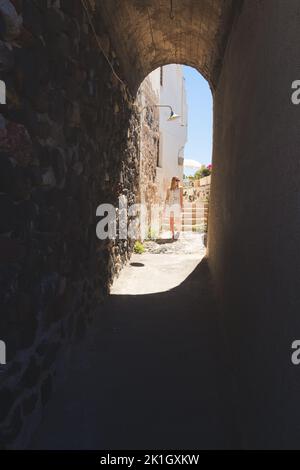 Une jeune femme blonde touristique explore et sillonne les rues pavées traditionnelles de la vieille ville dans le charmant et pittoresque village de Pyrgos Kal Banque D'Images