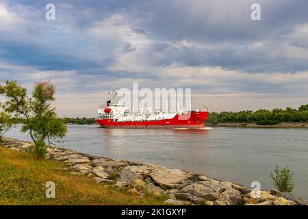 Photographie d'un navire de transport de gaz vu sur le Danube au lever du soleil. La photo a été prise de la rive de la rivière. Banque D'Images