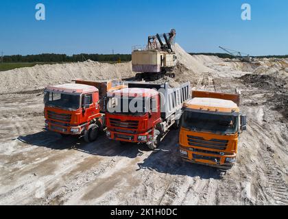 Des camions et des pelles hydrauliques à pointes colorées à ChalkQuarry en été Banque D'Images