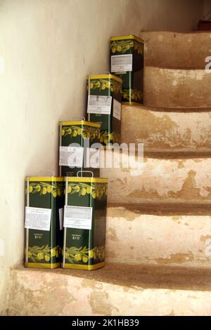 Tins of olive oil on the steps of an old residence in Salento, Italy. Stock Photo