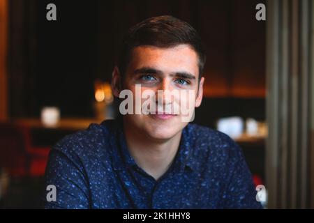 Flou artistique du jeune homme sur un arrière-plan vintage. Jeune homme souriant. 20s ans. Bel homme en plein air portrait. Style de vie. Étudiant. Hors foyer. Banque D'Images