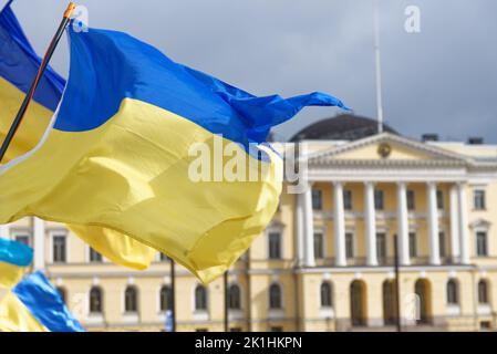 Helsinki, Finlande - 26 mars 2022 : drapeaux ukrainiens avec le Palais du Gouvernement finlandais en arrière-plan dans un rassemblement contre l'ac militaire russe Banque D'Images