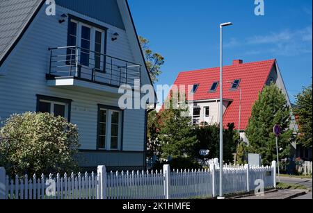 Une maison privée de deux étages avec un toit triangulaire et une zone près de la maison contre un ciel bleu Banque D'Images