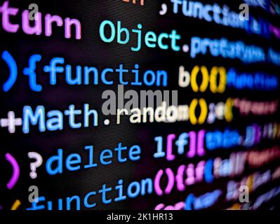 Gros plan du code logiciel de l'ordinateur sur un écran numérique avec des caractères colorés affichés en mode sombre sur fond noir Banque D'Images