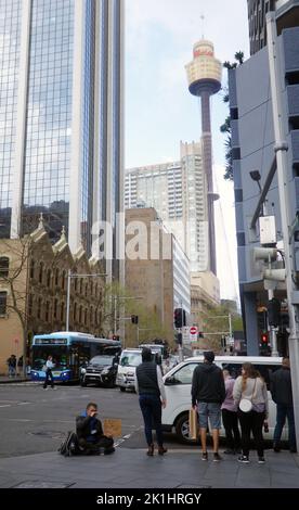 Homme sans domicile avec panneau demandant de l'argent, avec Centerpoint Tower en arrière-plan, quartier des affaires de Sydney, Nouvelle-Galles du Sud, Australie. Pas de MR Banque D'Images