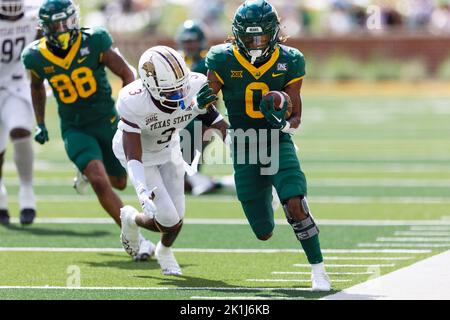 Baylor porte en arrière Craig Williams (0), en arrière de l'État du Texas Bobcat Corner back Kordell Rodgers (3) pour une course de touchdown de 30 yards avec 11:45 laissés dedans Banque D'Images