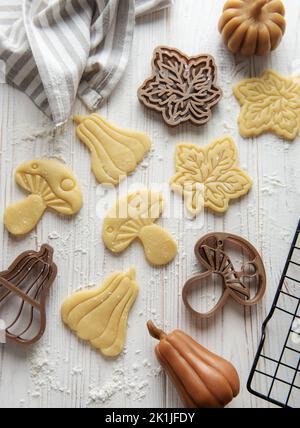 Cuisson de biscuits sous forme de citrouille et de feuilles. Pâtisserie d'automne confortable. Pâte avec emporte-pièces. Banque D'Images