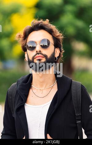 jeune homme élégant avec barbe et lunettes de soleil Banque D'Images