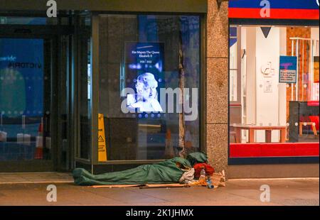 Londres Royaume-Uni 19th septembre 2022 - Un gros dormeur sous un portrait de la reine tandis que les foules se rassemblent près de la place du Parlement à Londres pour obtenir une vue des funérailles de la reine Elizabeth II aujourd'hui: Crédit Simon Dack / Alamy Live News Banque D'Images