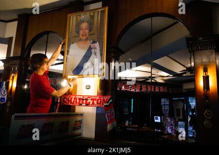 Makati City, RCN, Philippines. 19th septembre 2022. La mort de la reine Elizabeth II brise le cœur de nombreux ressortissants britanniques, y compris ceux de pays étrangers. Un bar britannique commémore la reine du Royaume-Uni au cœur de la ville de Makati, aux Philippines. La taverne Union Jack a placé un grand portrait de la Reine à leur mur. Les drapeaux britanniques sur les plafonds et les nouvelles britanniques diffusées à la télévision alors que le portrait est placé sur le mur. À l'entrée, les clients sont accueillis avec un autre portrait de la Reine souriant. (Credit image: © George BUID/ZUMA Press Wire) Credit: ZUMA Press, Inc. Credit: ZU Banque D'Images