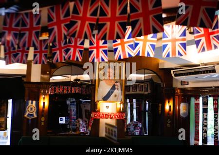 Makati City, RCN, Philippines. 19th septembre 2022. La mort de la reine Elizabeth II brise le cœur de nombreux ressortissants britanniques, y compris ceux de pays étrangers. Un bar britannique commémore la reine du Royaume-Uni au cœur de la ville de Makati, aux Philippines. La taverne Union Jack a placé un grand portrait de la Reine à leur mur. Les drapeaux britanniques sur les plafonds et les nouvelles britanniques diffusées à la télévision alors que le portrait est placé sur le mur. À l'entrée, les clients sont accueillis avec un autre portrait de la Reine souriant. (Credit image: © George BUID/ZUMA Press Wire) Credit: ZUMA Press, Inc. Credit: ZU Banque D'Images