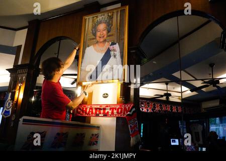 Makati City, RCN, Philippines. 19th septembre 2022. La mort de la reine Elizabeth II brise le cœur de nombreux ressortissants britanniques, y compris ceux de pays étrangers. Un bar britannique commémore la reine du Royaume-Uni au cœur de la ville de Makati, aux Philippines. La taverne Union Jack a placé un grand portrait de la Reine à leur mur. Les drapeaux britanniques sur les plafonds et les nouvelles britanniques diffusées à la télévision alors que le portrait est placé sur le mur. À l'entrée, les clients sont accueillis avec un autre portrait de la Reine souriant. Crédit : ZUMA Press, Inc./Alay Live News Banque D'Images