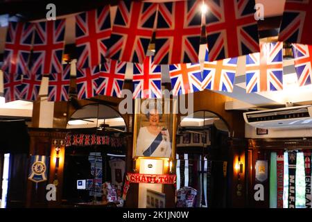 Makati City, RCN, Philippines. 19th septembre 2022. La mort de la reine Elizabeth II brise le cœur de nombreux ressortissants britanniques, y compris ceux de pays étrangers. Un bar britannique commémore la reine du Royaume-Uni au cœur de la ville de Makati, aux Philippines. La taverne Union Jack a placé un grand portrait de la Reine à leur mur. Les drapeaux britanniques sur les plafonds et les nouvelles britanniques diffusées à la télévision alors que le portrait est placé sur le mur. À l'entrée, les clients sont accueillis avec un autre portrait de la Reine souriant. Crédit : ZUMA Press, Inc./Alay Live News Banque D'Images