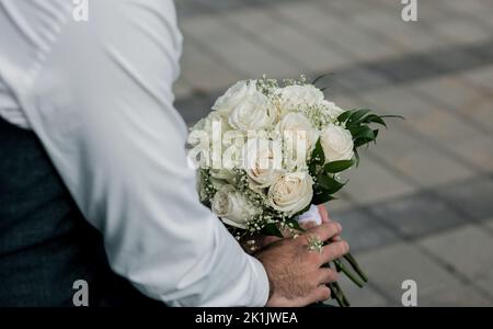 chambre avec un bouquet blanc dans un costume classique, extérieur Banque D'Images