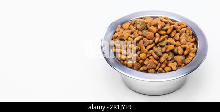 Sécher les aliments granulés dans un bol en métal pour chats et chiens. Soins aux animaux, vitamines et nutrition équilibrée des animaux de compagnie. Photo de haute qualité Banque D'Images