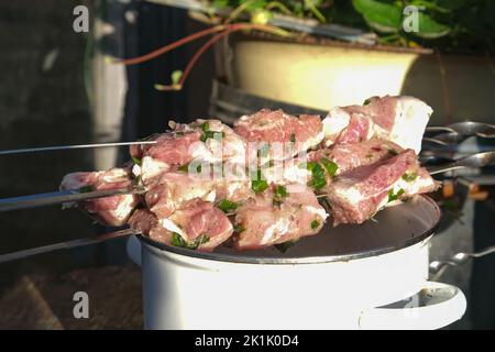 Viande marinée sur des brochettes couchées sur une casserole. Viande marinée avec des herbes prêtes à cuire sur des charbons. Banque D'Images