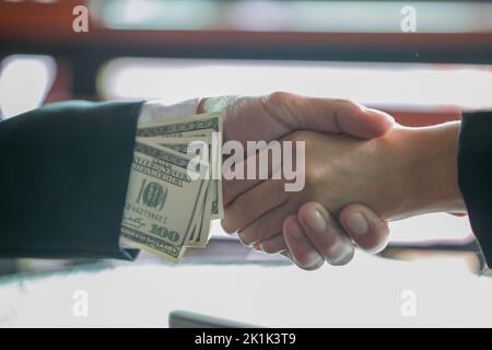 Un homme d'affaires corrompu a conclu la transaction avec une poignée de main et a reçu un pot-de-vin, des concepts anti-corruption et de corruption Banque D'Images