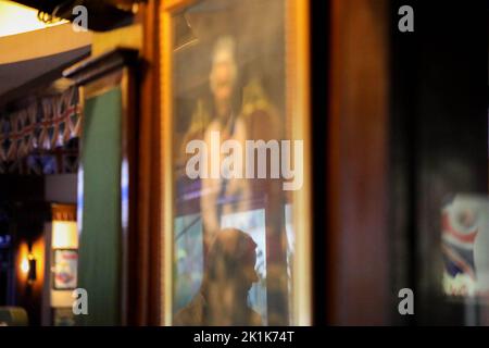 Manille, Philippines. 19th septembre 2022. Une femme entre dans un pub britannique à Makati City, aux Philippines, avec un portrait de la reine Elizabeth II à temps pour ses funérailles d'État à Londres, en Angleterre. 19 septembre 2022. La reine Elizabeth II, le monarque le plus ancien de Grande-Bretagne, est morte sur 8 septembre 2022, après 70 ans sur le trône. Elle avait 96 ans. (Image de crédit : © Basilio Sepe/ZUMA Press Wire) Banque D'Images