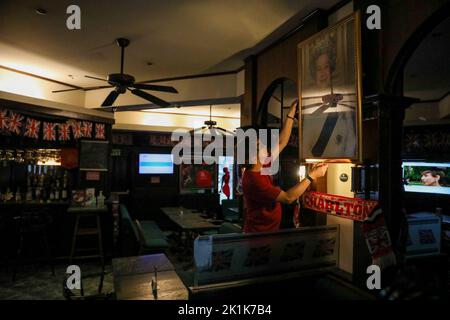 Manille, Philippines. 19th septembre 2022. Un membre du personnel présente un portrait de la reine Elizabeth II dans un pub britannique à Makati City, aux Philippines, à temps pour ses funérailles d'État à Londres, en Angleterre. 19 septembre 2022. La reine Elizabeth II, le monarque le plus ancien de Grande-Bretagne, est morte sur 8 septembre 2022, après 70 ans sur le trône. Elle avait 96 ans. (Image de crédit : © Basilio Sepe/ZUMA Press Wire) Banque D'Images