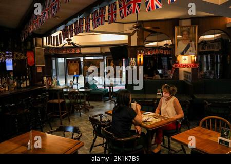 Manille, Philippines. 19th septembre 2022. Les clients dînent à l'intérieur d'un pub britannique à Makati City, aux Philippines, avec un portrait de la reine Elizabeth II à temps pour ses funérailles d'État à Londres, en Angleterre. 19 septembre 2022. La reine Elizabeth II, le monarque le plus ancien de Grande-Bretagne, est morte sur 8 septembre 2022, après 70 ans sur le trône. Elle avait 96 ans. (Image de crédit : © Basilio Sepe/ZUMA Press Wire) Banque D'Images