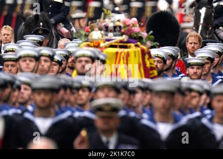 Le duc de Sussex suit le chariot d'armes d'État en portant le cercueil de la reine Elizabeth II, drapé dans le Standard royal avec la Couronne d'État impériale et l'orbe et le sceptre du souverain, dans le procession de cérémonie durant son funérailles d'État à l'abbaye de Westminster, à Londres. Date de la photo: Lundi 19 septembre 2022. Banque D'Images