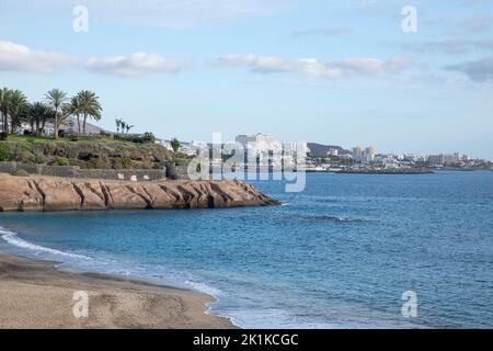 Vue imprenable sur la plage populaire, l'océan bleu calme et la côte voisine avec de l'herbe verte et des jardins tropicaux luxuriants, Playa del Duque, Costa Adeje Banque D'Images