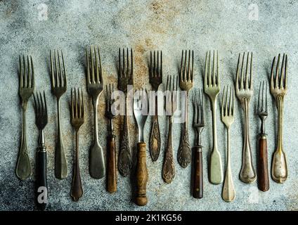 Vue en hauteur d'une rangée de fourchettes vintage assorties sur une table Banque D'Images