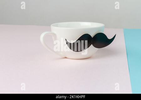 Gros plan sur une tasse en céramique blanche avec moustache. Concept de jour des Pères. Banque D'Images
