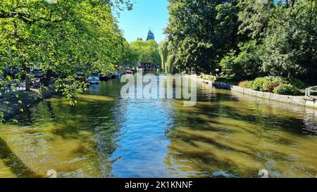 Chaîne à Amsterdam pays-Bas. Grands arbres près de la rivière Amstel site touristique. Paysage d'été de la vieille ville européenne Banque D'Images
