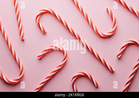 Motif de canne à sucre à rayures dures sur fond rose. Arrière-plan des fêtes de Noël Banque D'Images