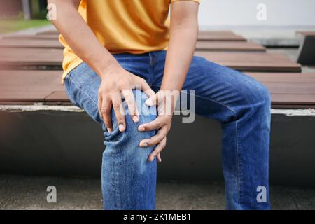 jeune homme souffrant de douleurs aux pieds assis sur le banc du parc Banque D'Images