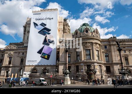 Affiche publicitaire géant Samsung Galaxy Z Flip4 couvrant les échafaudages des travaux de restauration sur la façade latérale de l'Opéra Garnier de Paris Banque D'Images