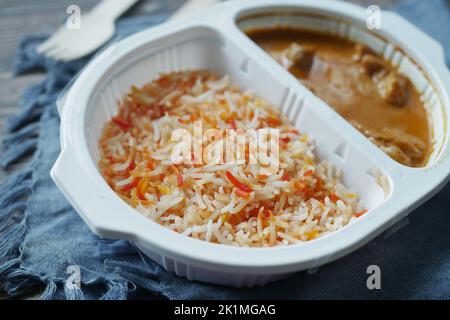 curry de poulet et de riz dans un sachet en plastique à emporter sur la table Banque D'Images