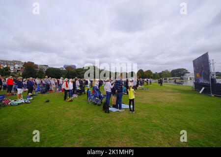 Des centaines de personnes se sont rassemblées dans le parc Poole Dorset à regarder sur le grand écran Queen Elizabeth II Funeral 19/09/2022 . Les funérailles de la Reine de l'abbaye de Westminster et la marche funéraire au château de Windsor ont été présentées sur de grands écrans à travers le Royaume-Uni. Poole Park a vu un grand rassemblement de personnes qui ont regardé les funérailles par le grand écran et plus tard montré leurs respects se tenant pour l'hymne national. Banque D'Images