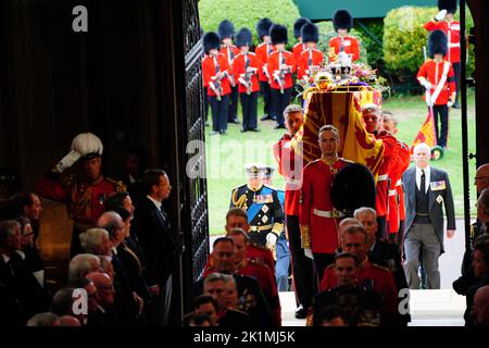 Le roi Charles III (à gauche) suit alors que les porteurs de cercueils transportent le cercueil de la reine Elizabeth II dans la chapelle Saint-Georges du château de Windsor, dans le Berkshire, pour le service de committal. Date de la photo: Lundi 19 septembre 2022. Banque D'Images