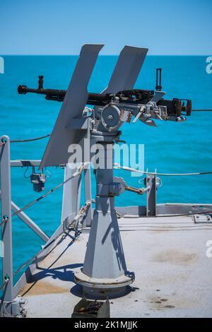 Image couleur d'une mitrailleuse automatique sur le pont d'un navire militaire, en mer. Banque D'Images