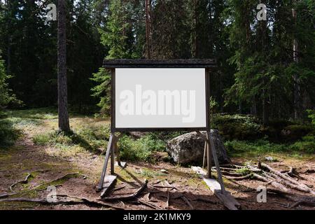 Panneau blanc vierge dans une forêt de pins scandinaves en été Banque D'Images