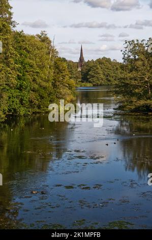 Rivière traversant le parc Clumber avec la chapelle Sainte-Marie-la-Vierge au loin. Banque D'Images