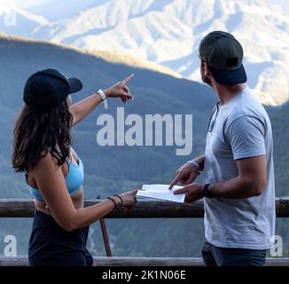 young boys looking at a map in the mountains Stock Photo