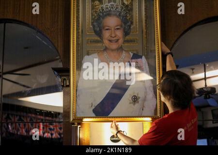 Manille, Philippines. 19th septembre 2022. Un membre du personnel présente un portrait de la reine Elizabeth II dans un pub britannique à Makati City, aux Philippines, à temps pour ses funérailles d'État à Londres, en Angleterre. 19 septembre 2022. La reine Elizabeth II, le monarque le plus ancien de Grande-Bretagne, est morte sur 8 septembre 2022, après 70 ans sur le trône. Elle avait 96 ans. (Image de crédit : © Basilio Sepe/ZUMA Press Wire) Banque D'Images